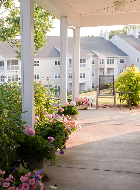 View of Kendal at Lexington apartment buildings from nearby porch with pink roses