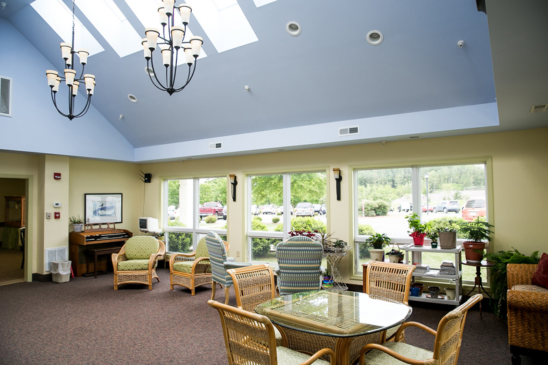 Private sitting room with table and chairs and armchairs near garden windows