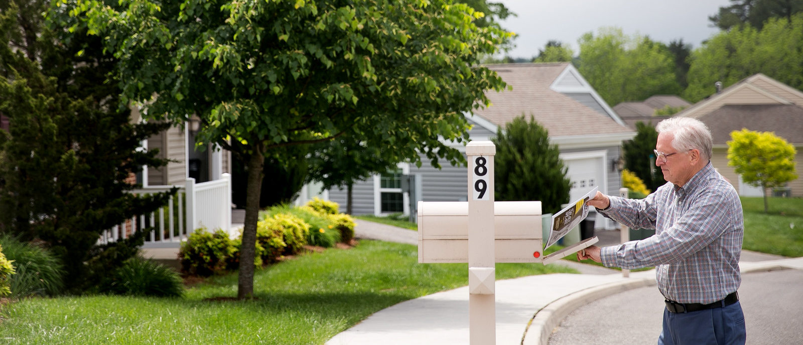 overview of kendal at lexington cottages - resident placing letter in mailbox