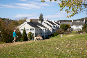 woman and dog walking in center of campus
