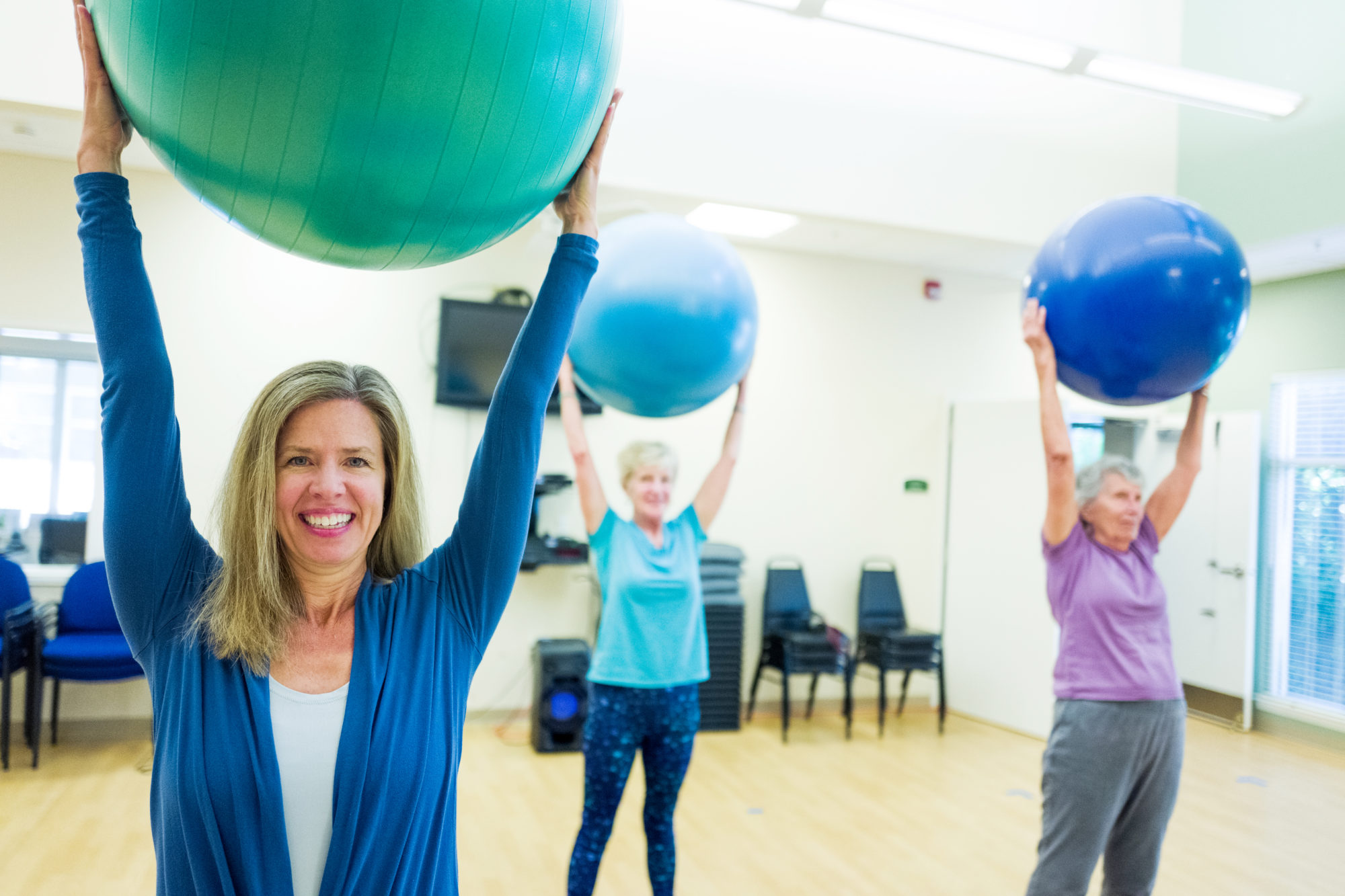 fitness manager leading class with ball