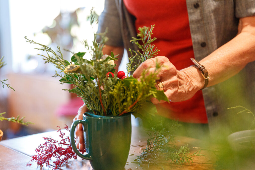 Resident works on floral arrangement for arts and crafts fair.